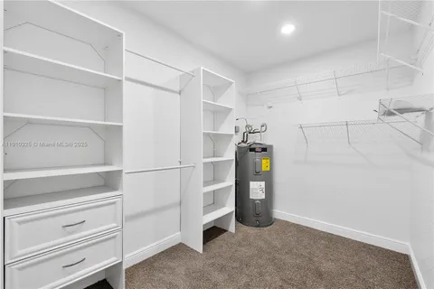 a kitchen with stainless steel appliances granite countertop a refrigerator a sink a stove and white cabinets