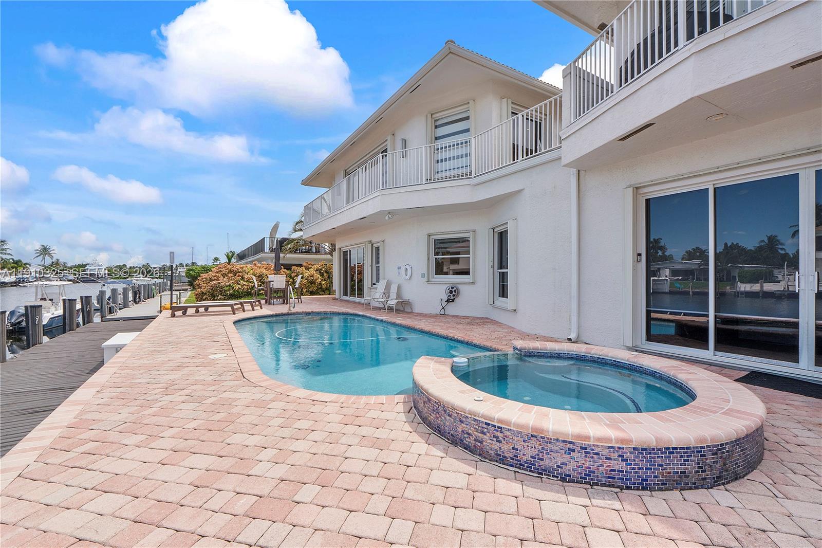 2737 Northeast 28th Court, Unit 1 Lighthouse Point, FL 33064 - Photo 3 of 46 a swimming pool with outdoor seating