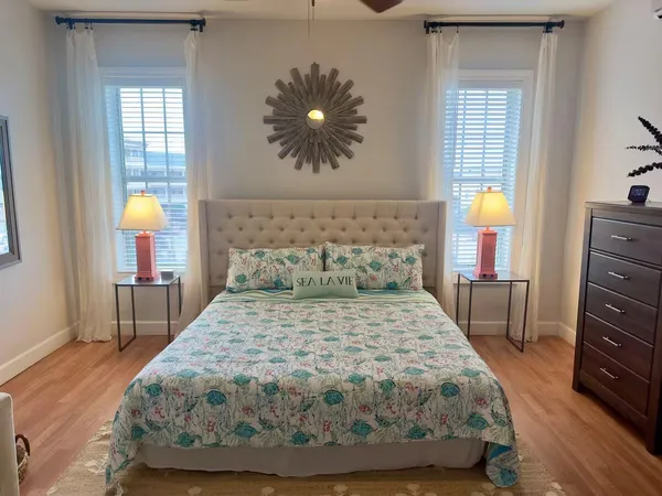 a bedroom with a bed and a lamp on dresser