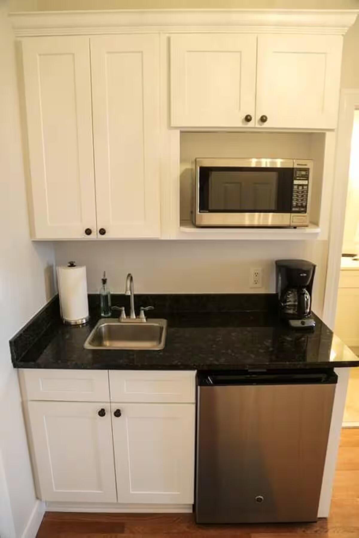 10343 East County Highway 30A, Unit B381 Inlet Beach, FL 32413 - Photo 7 of 20 a kitchen with granite countertop white cabinets and black appliances