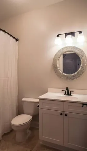 a bathroom with a sink a toilet and a mirror