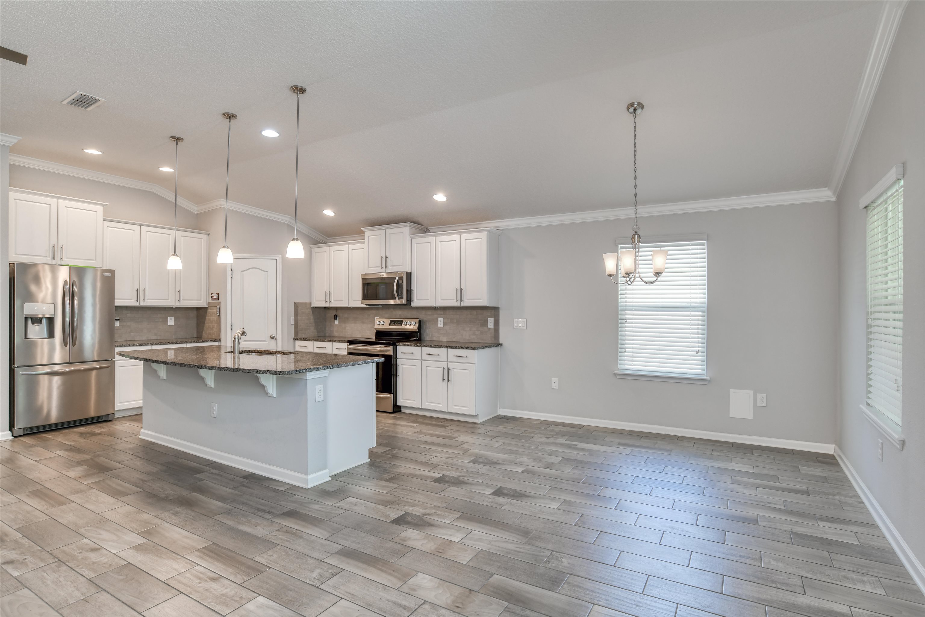 485 Crescent Key Drive St. Augustine, FL 32086 - Photo 12 of 46 a kitchen with stainless steel appliances kitchen island granite countertop a refrigerator a oven a white stove a sink and white cabinets with wooden floor
