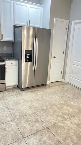 a view of a kitchen with refrigerator and cabinets