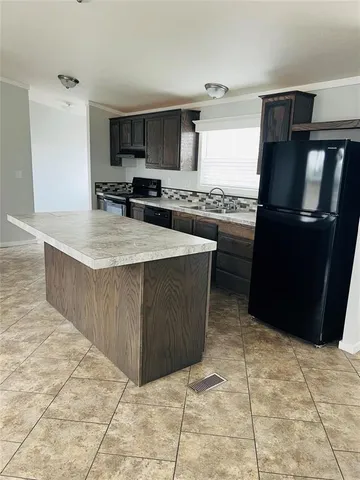 a kitchen with stainless steel appliances granite countertop a stove a refrigerator a sink and dishwasher