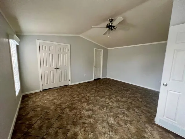 an empty room with a ceiling fan and carpet