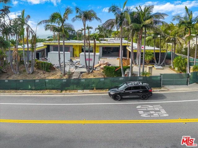 a view of a swimming pool and trees in front of a house