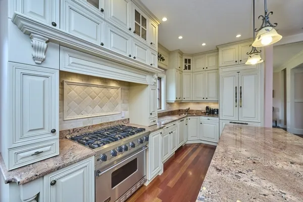 a kitchen with a stove and white cabinets