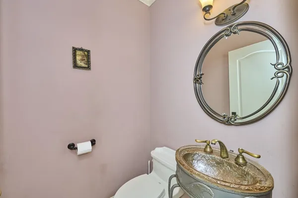 a bathroom with a toilet mirror and vanity