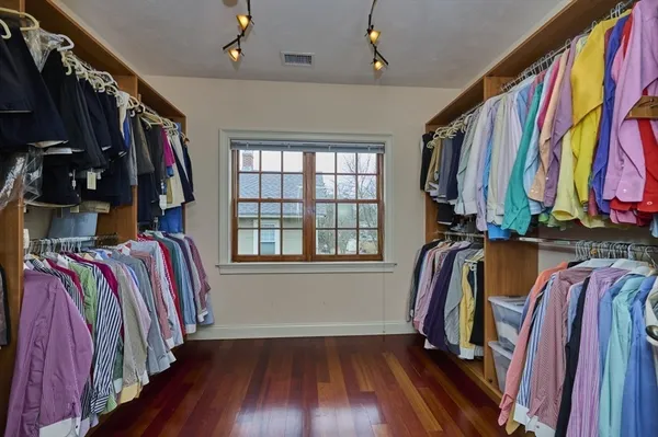 a view of walk in closet with clothes and shoes