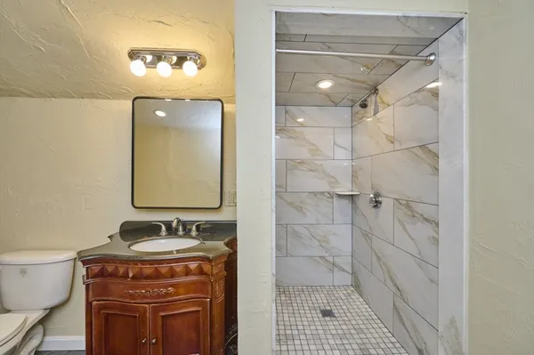 a bathroom with a sink a toilet and shower