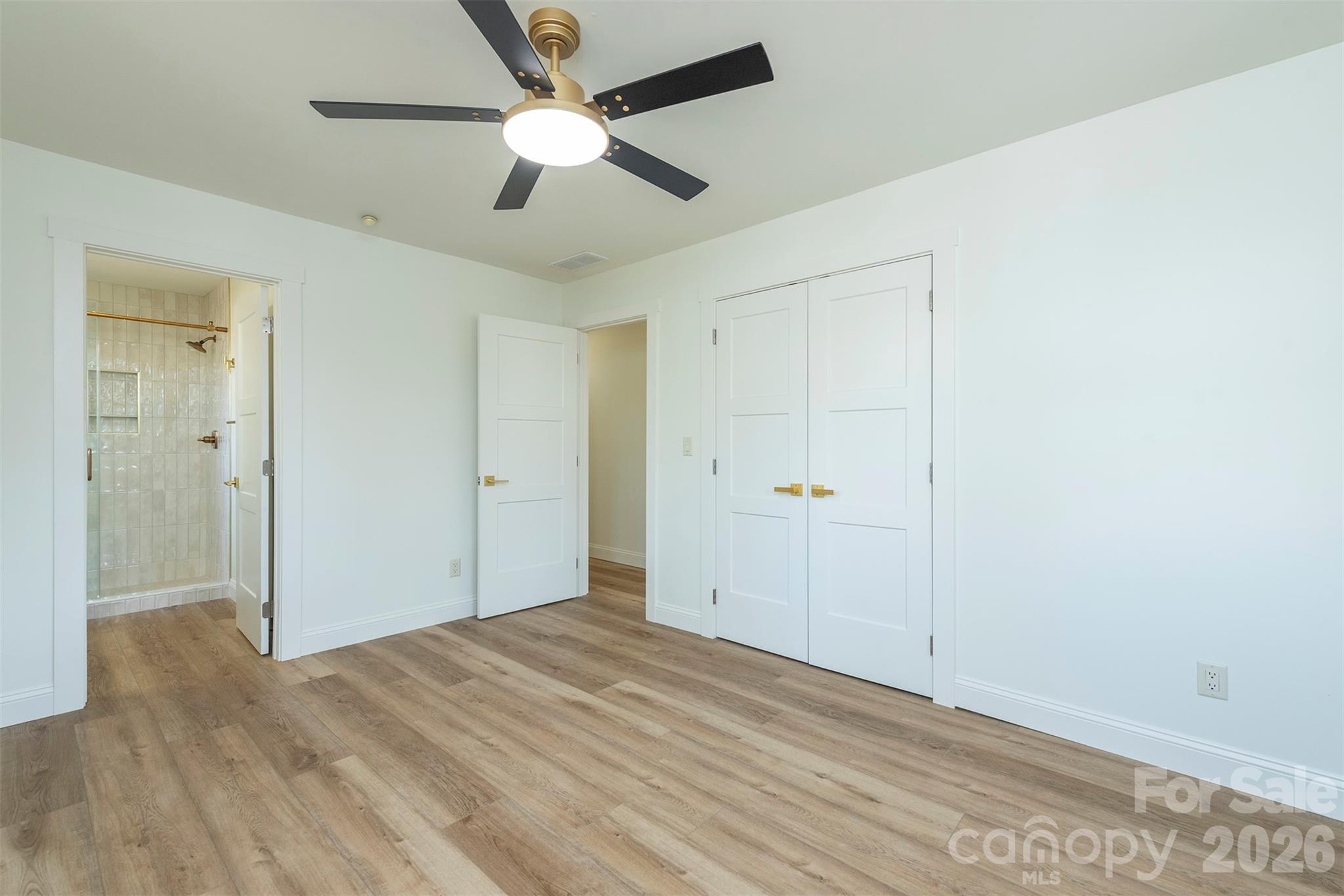 524 Pineland Road Hendersonville, NC 28792 - Photo 21 of 36 a view of a big room with wooden floor and a ceiling fan