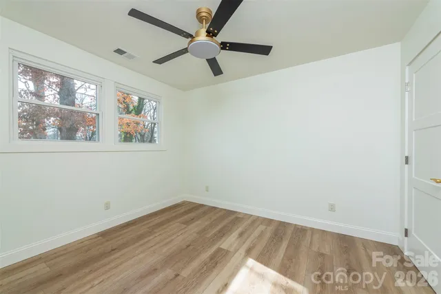 an empty room with a window and a ceiling fan