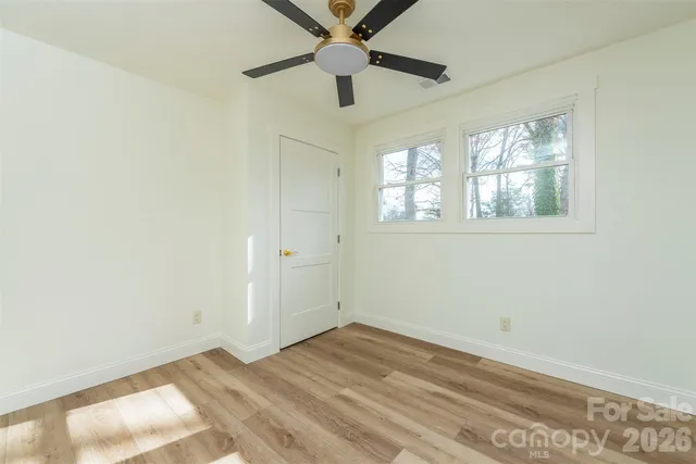 an empty room with a window and a ceiling fan