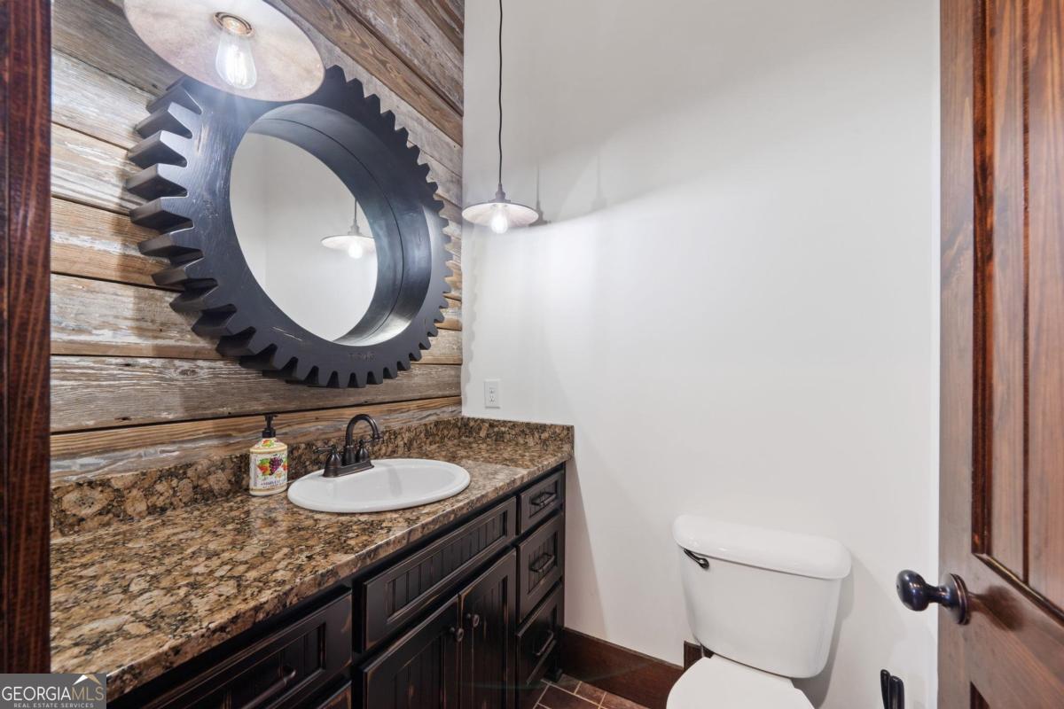 4096 Big Water E Road Sparta, GA 31087 - Photo 12 of 70 a bathroom with a granite countertop sink and a mirror