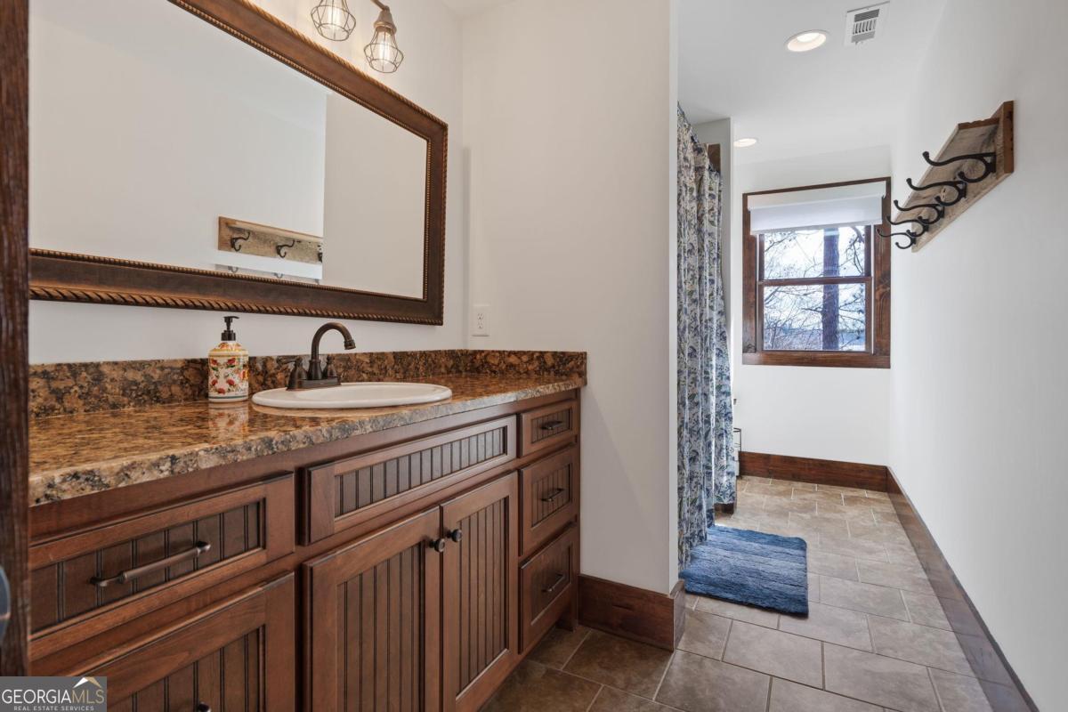 4096 Big Water E Road Sparta, GA 31087 - Photo 51 of 70 a bathroom with a granite countertop sink a mirror and vanity