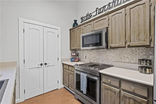 a kitchen with stainless steel appliances white cabinets and a stove top oven