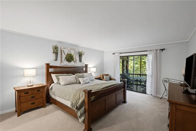 a bedroom with a bed and a flat tv screen on a dresser