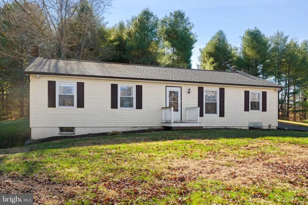 a view of a house with backyard and trees