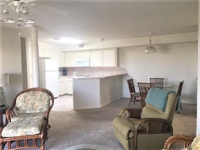 a living room with furniture a fireplace and a chandelier