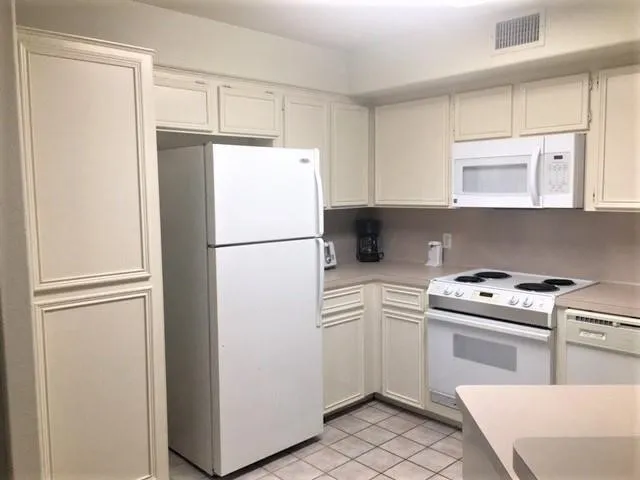 a kitchen with a refrigerator sink stove and cabinets