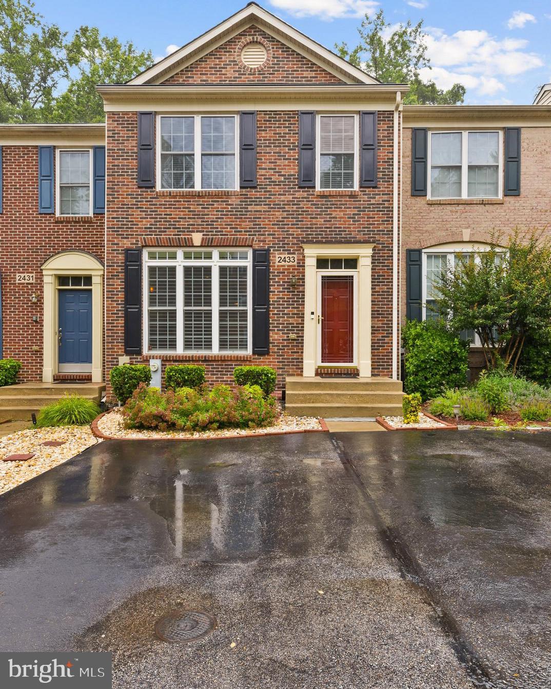 front view of a brick house with a yard