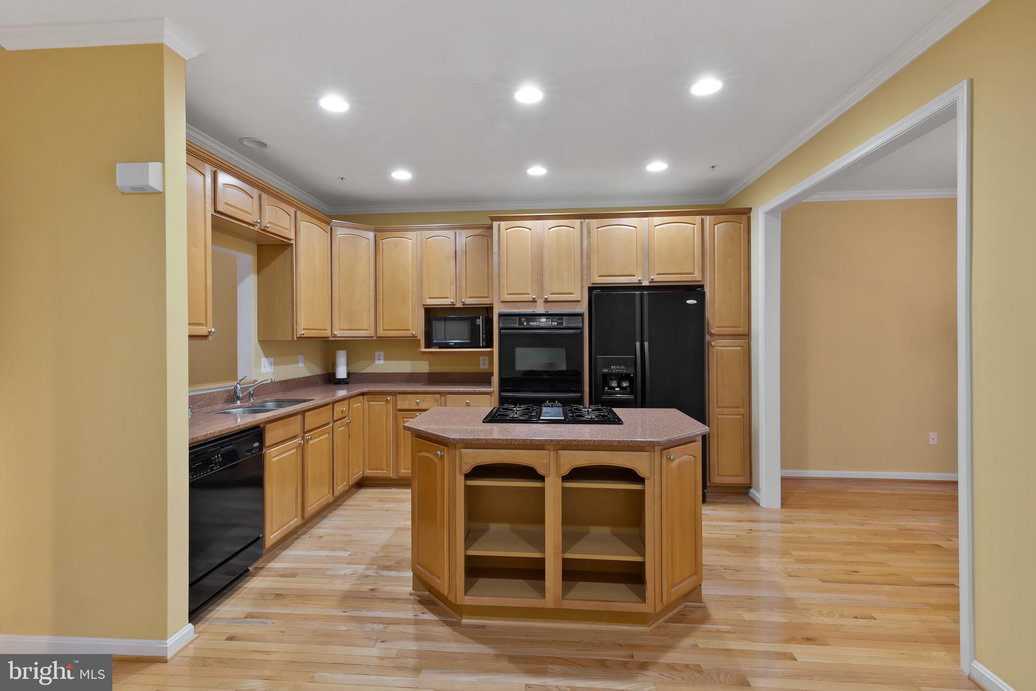 2433 Killarney Terrace Odenton, MD 21113 - Photo 9 of 48 a kitchen with kitchen island stainless steel appliances a stove a sink and a refrigerator