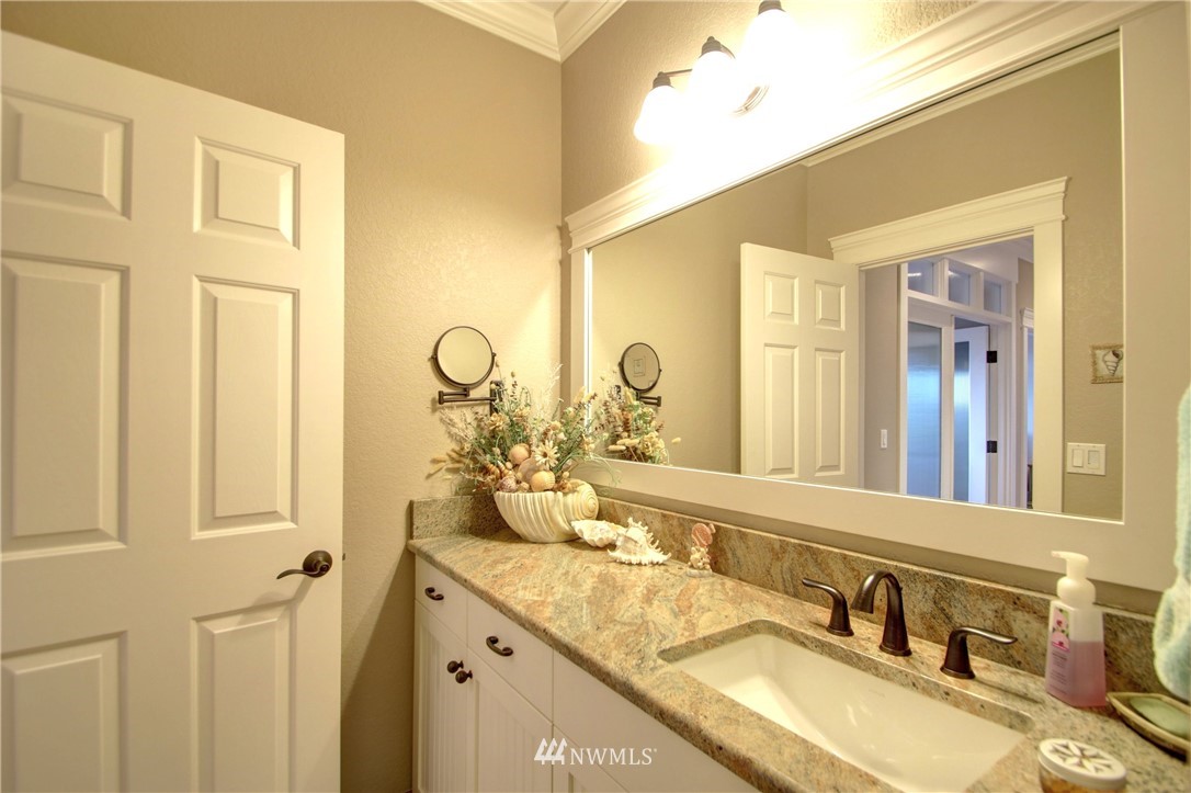 3907 Ridgetop Anacortes, WA 98221 - Photo 17 of 23 a bathroom with a granite countertop sink and a mirror