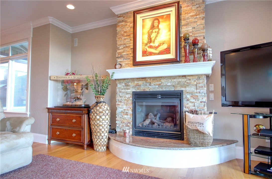 3907 Ridgetop Anacortes, WA 98221 - Photo 9 of 23 a living room with furniture a flat screen tv and a fireplace