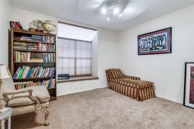 a living room with furniture a bookshelf and a window