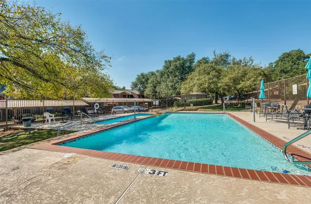 a view of a swimming pool with a yard and sitting area