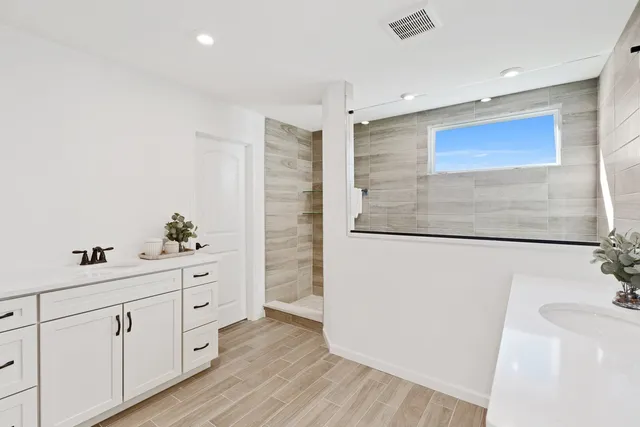 a spacious bathroom with a double vanity sink and mirror
