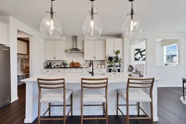 a dining room with wooden floor a chandelier a wooden table and chairs