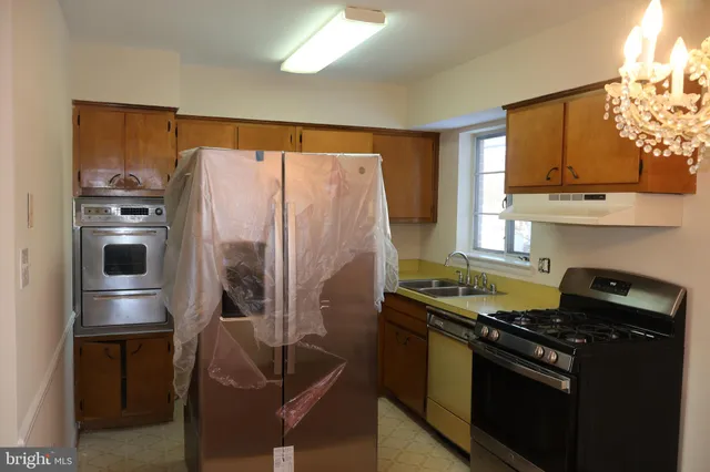 a kitchen with stainless steel appliances granite countertop a refrigerator and a stove