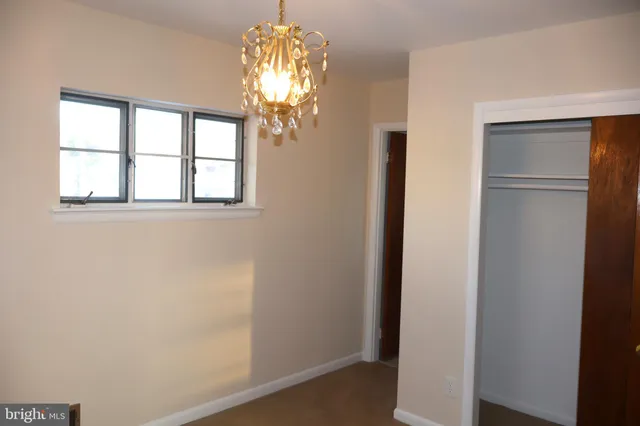 a view of a hallway with wooden floor and chandelier