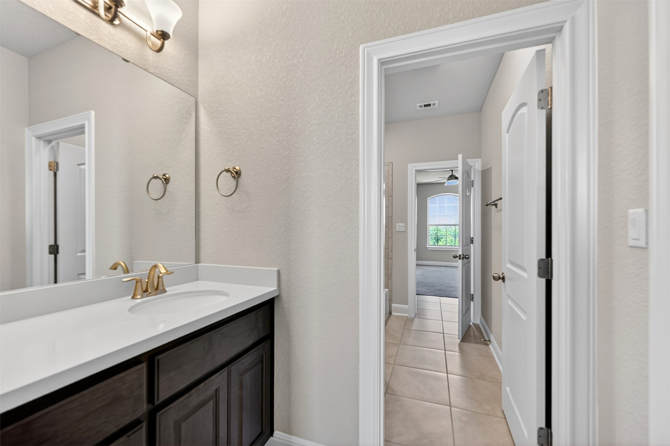 1201 Positano Pass Leander, TX 78641 - Photo 37 of 40 Bathroom vanity featuring a single basin sink, brass-finish faucet, and white countertop