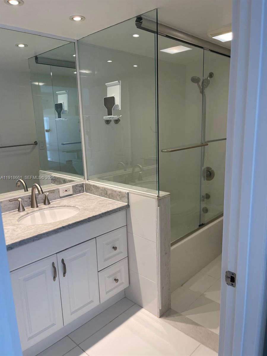 16909 North Bay Road, Unit 716 Sunny Isles Beach, FL 33160 - Photo 19 of 26 a bathroom with a shower sink and mirror