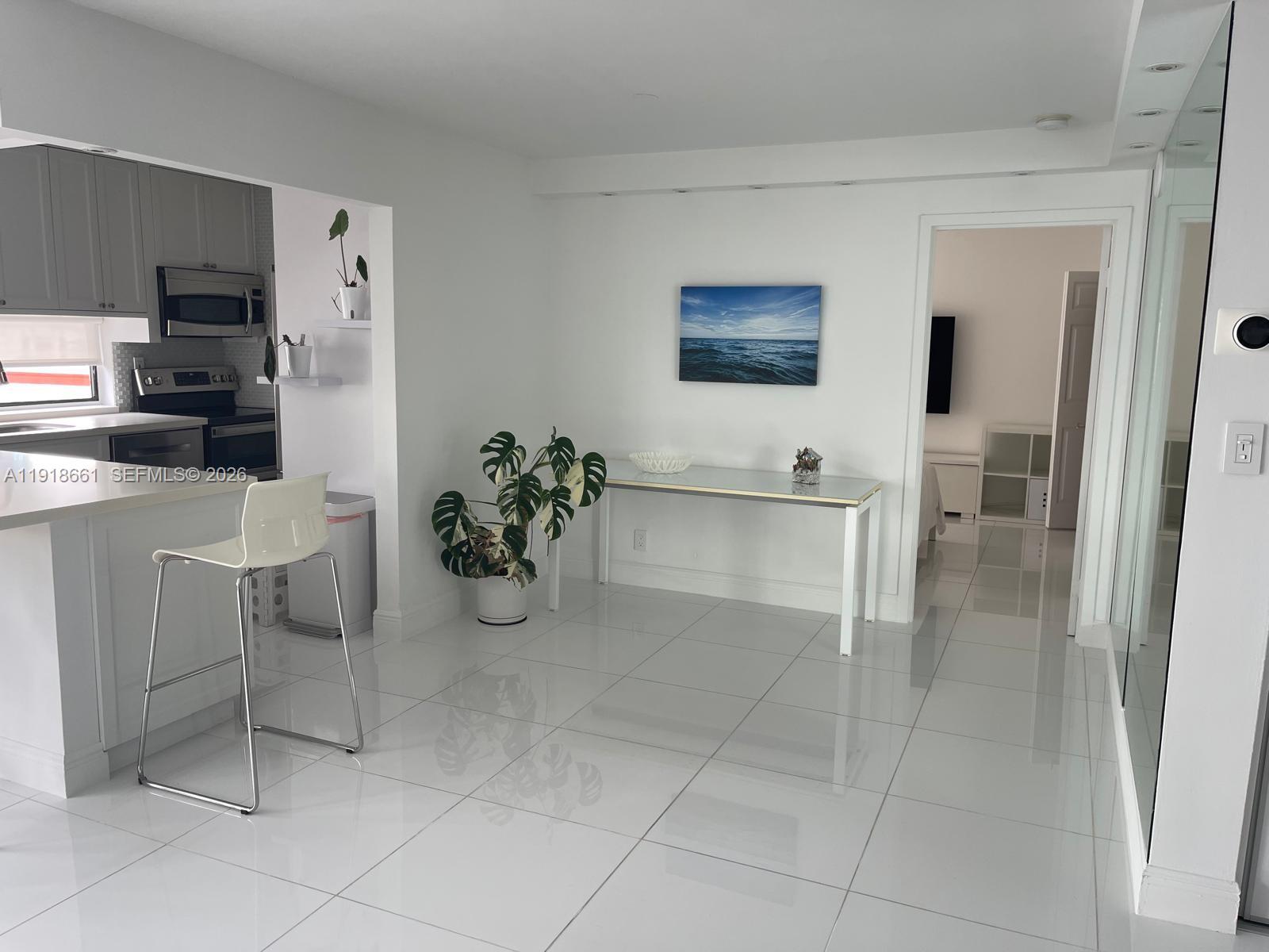 16909 North Bay Road, Unit 716 Sunny Isles Beach, FL 33160 - Photo 23 of 26 a living room with furniture a rug and white appliances