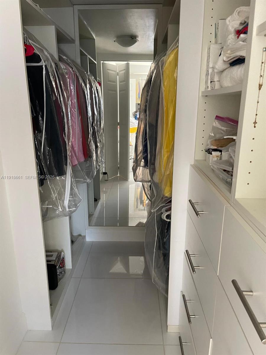 16909 North Bay Road, Unit 716 Sunny Isles Beach, FL 33160 - Photo 24 of 26 a view of walk in closet with clothes and shoes
