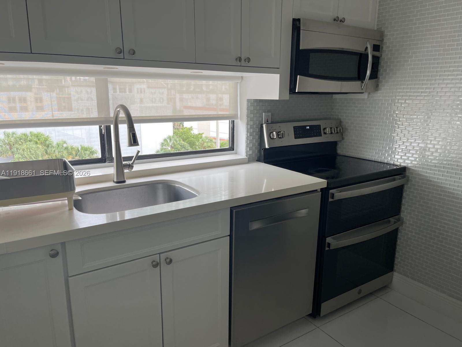 16909 North Bay Road, Unit 716 Sunny Isles Beach, FL 33160 - Photo 4 of 26 a kitchen with a sink and a microwave