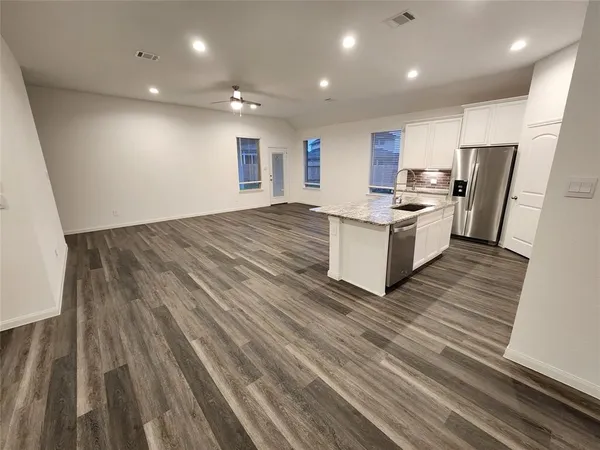 a kitchen with a sink and wooden floor