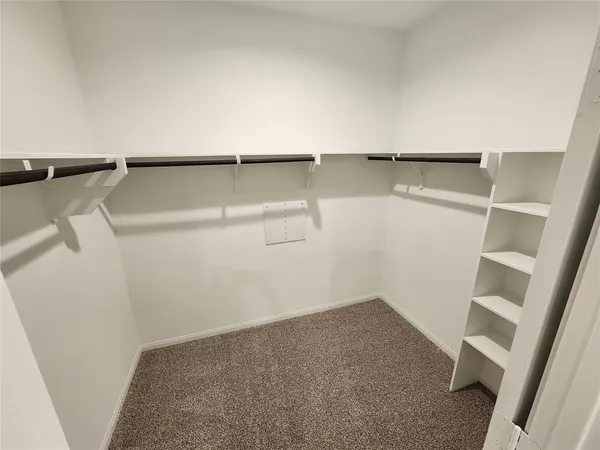 a view of walk in closet with empty racks