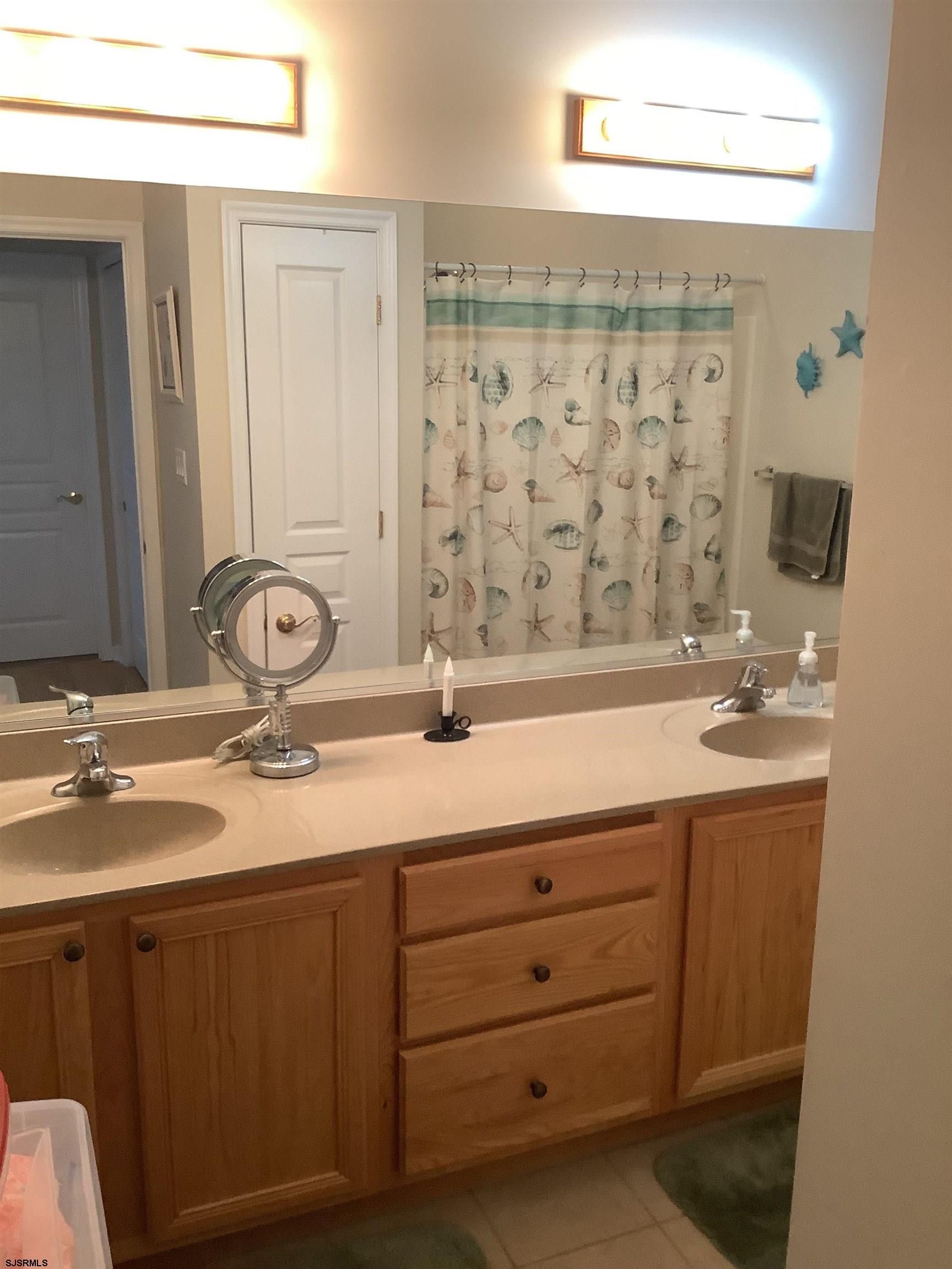 1731 South Shore Road, Unit 128 Marmora, NJ 08230 - Photo 11 of 13 a bathroom with a double vanity sink and a mirror