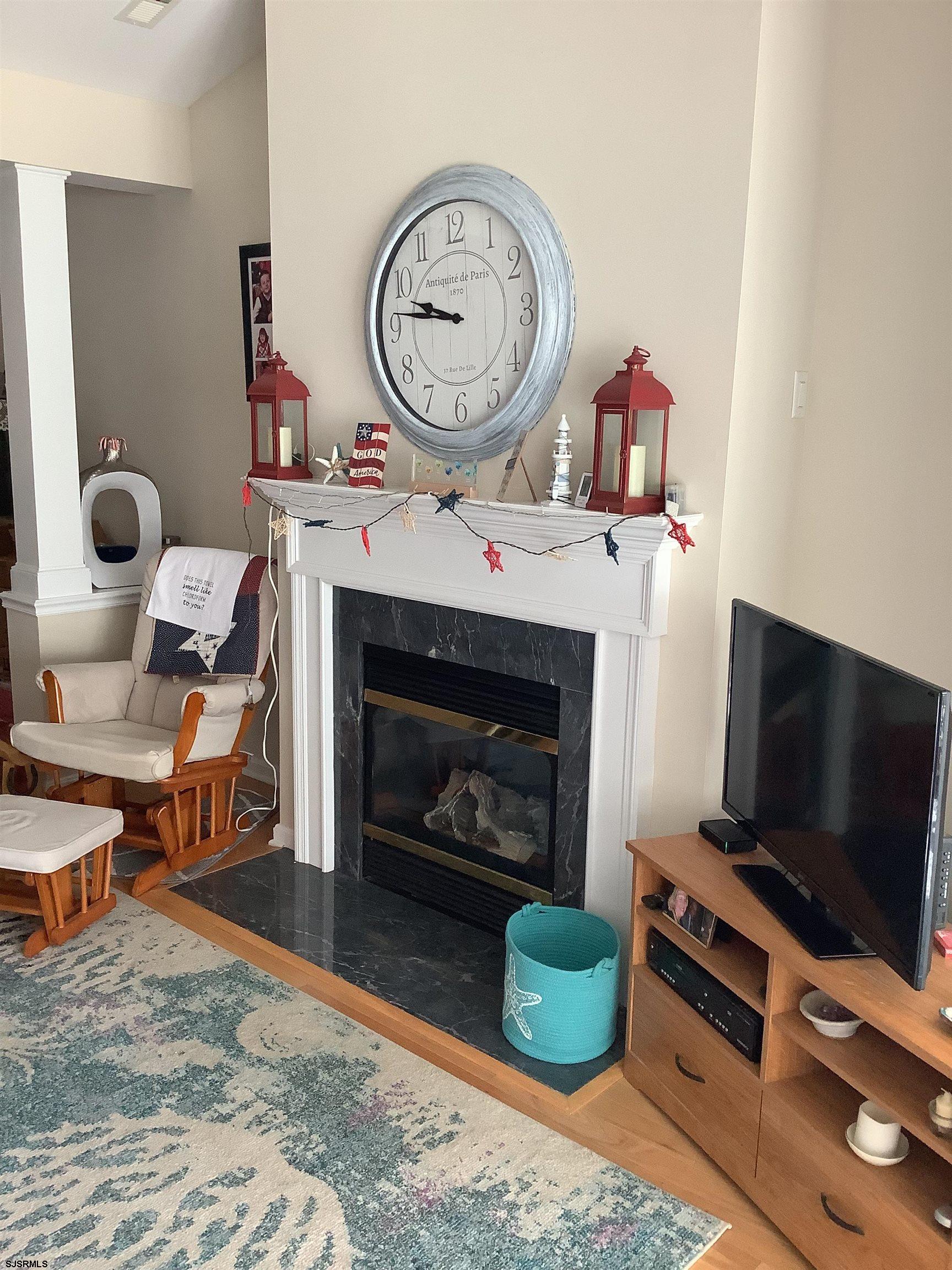 1731 South Shore Road, Unit 128 Marmora, NJ 08230 - Photo 3 of 13 a living room with furniture a flat screen tv and a fireplace