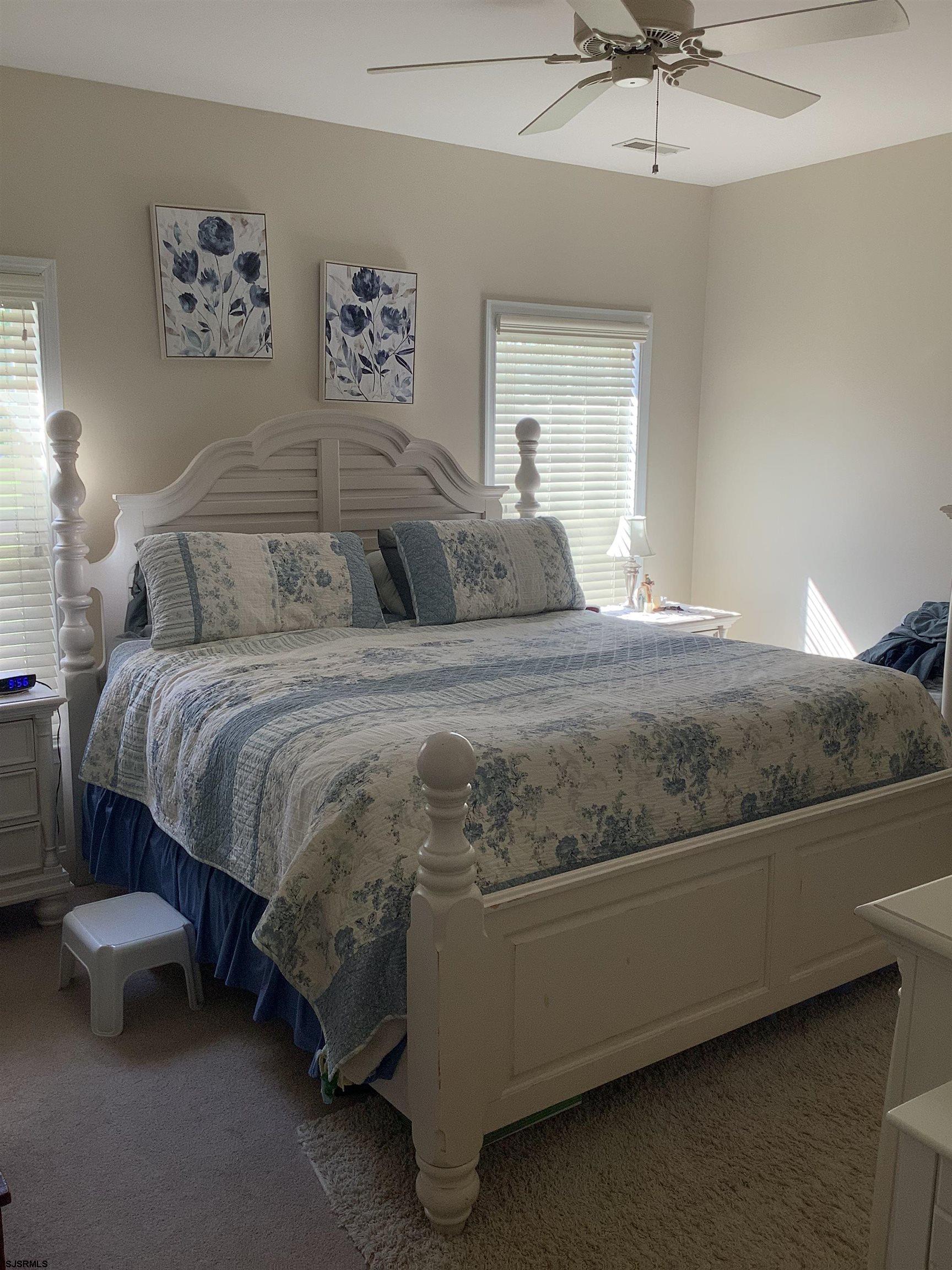 1731 South Shore Road, Unit 128 Marmora, NJ 08230 - Photo 9 of 13 a bedroom with a bed and a chandelier