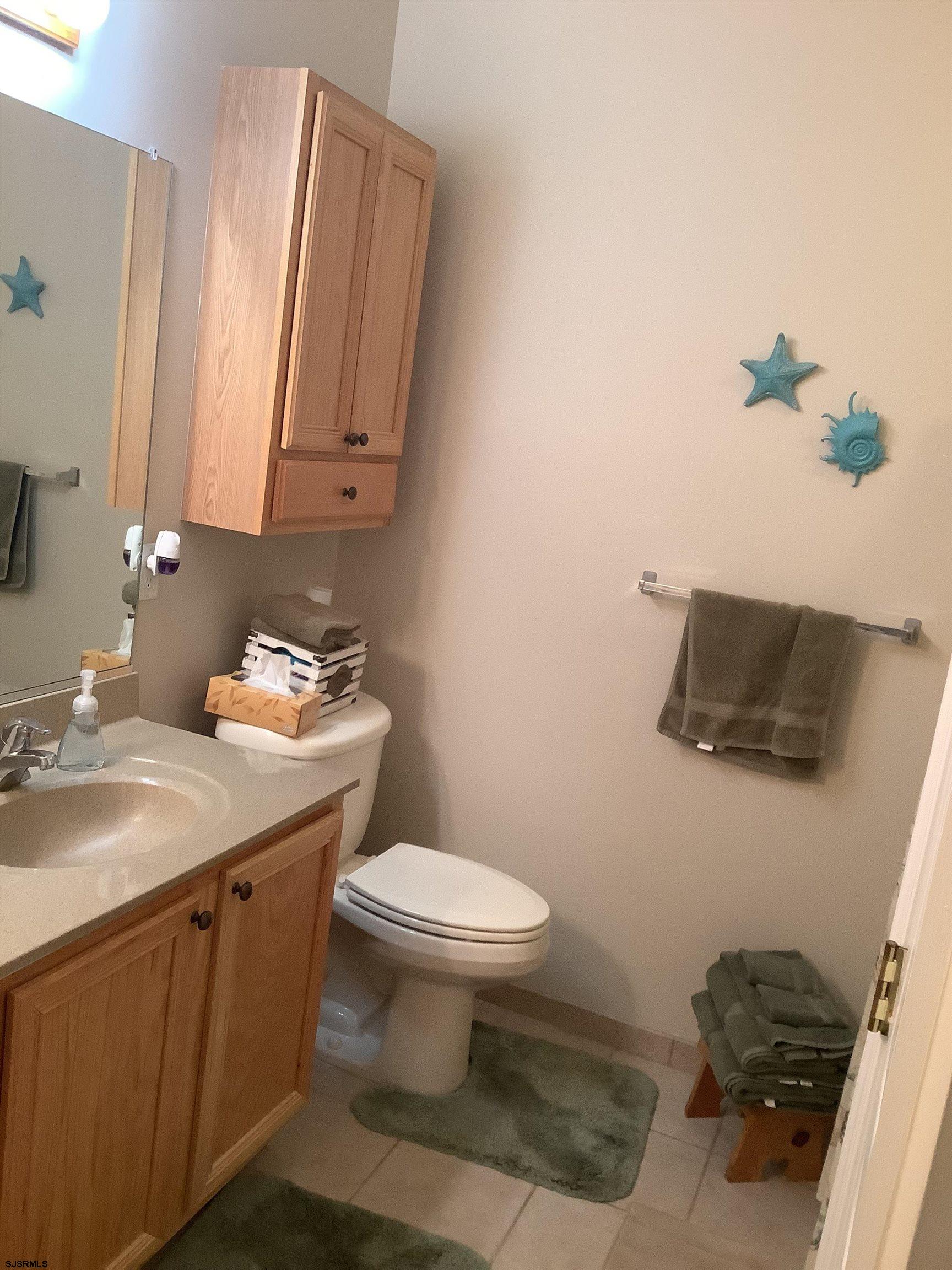 1731 South Shore Road, Unit 128 Marmora, NJ 08230 - Photo 10 of 13 a bathroom with a sink toilet and mirror