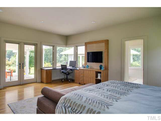 6705 Green Rise Road Hillsborough, NC 27278 - Photo 11 of 24 a bedroom with a large bed and a flat tv screen next to a window