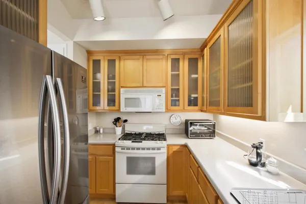 a kitchen with stainless steel appliances a refrigerator sink and cabinets