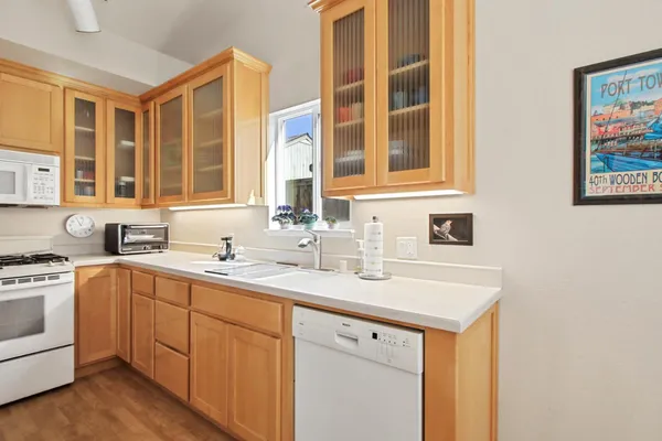 a utility room with stainless steel appliances granite countertop a sink and dishwasher next to a window