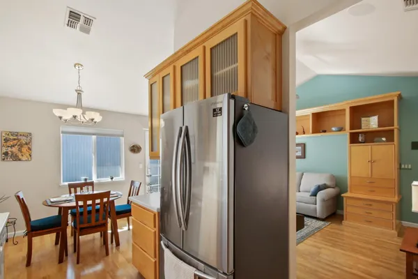 a kitchen with stainless steel appliances a refrigerator a table and chairs