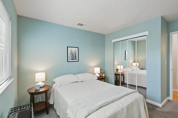 a bedroom with a bed and a lamp on table